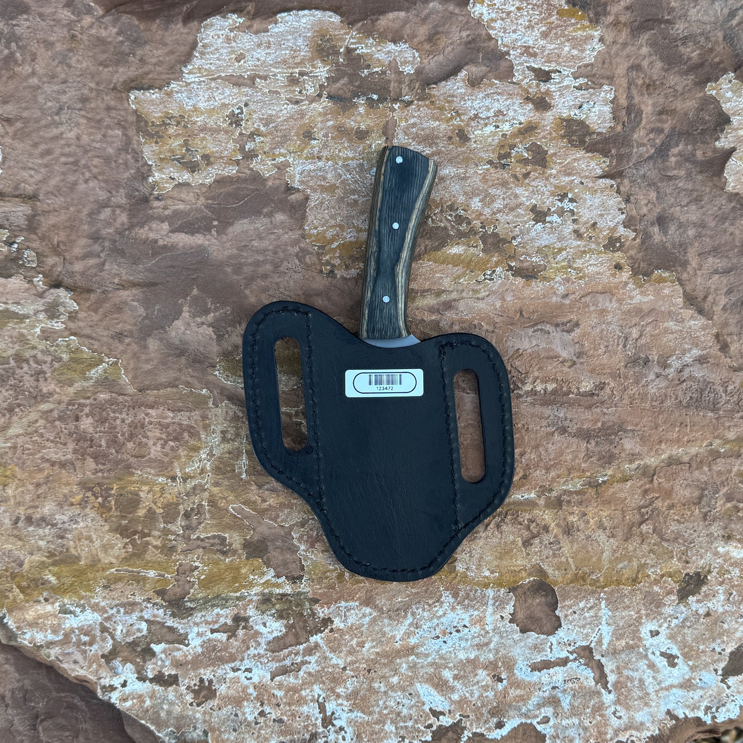 A full-tang drop-point field knife with a satin-finished blade and dark-wood handle, triple-riveted for strength, photographed for Blue Spade Forge. Shown with its handcrafted leather sheath, highlighting the rugged outdoor style and premium construction