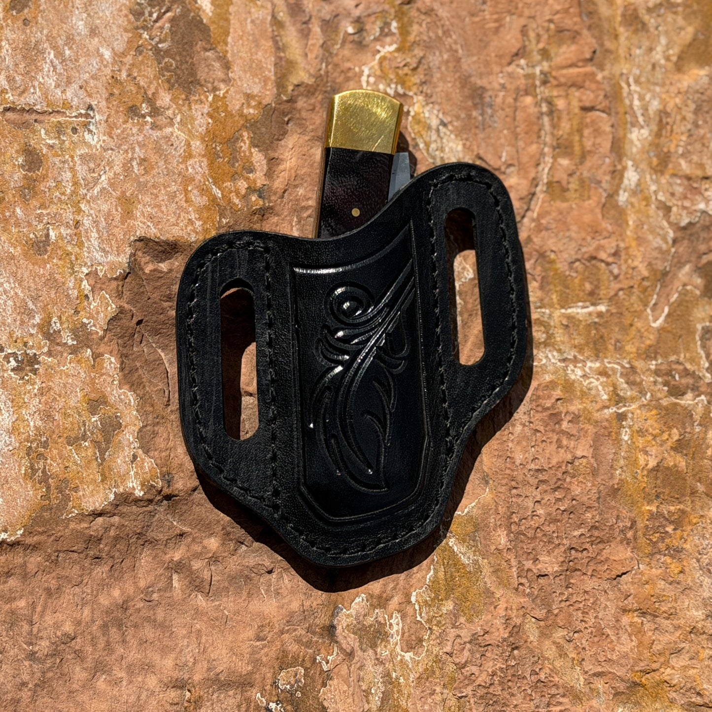 folding knife with leather belt sheath horizontal carry style
traditional pocket knife outdoor product photo on rock surface
Blue Spade Forge rosewood and brass folding knife EDC setup
