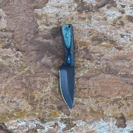 Blue Timber Rasp Knife with rasp-textured blade

Full-tang rasp knife on brown leather sheath

Blue and gray wood-grain handle close-up

Heavy-duty fixed blade displayed on wood background

Knife and hand-stitched leather sheath arranged together

Blue Timber Rasp Knife held in hand for scale

Outdoor utility knife in natural lighting

Rasp-style blade and wood handle detail shot