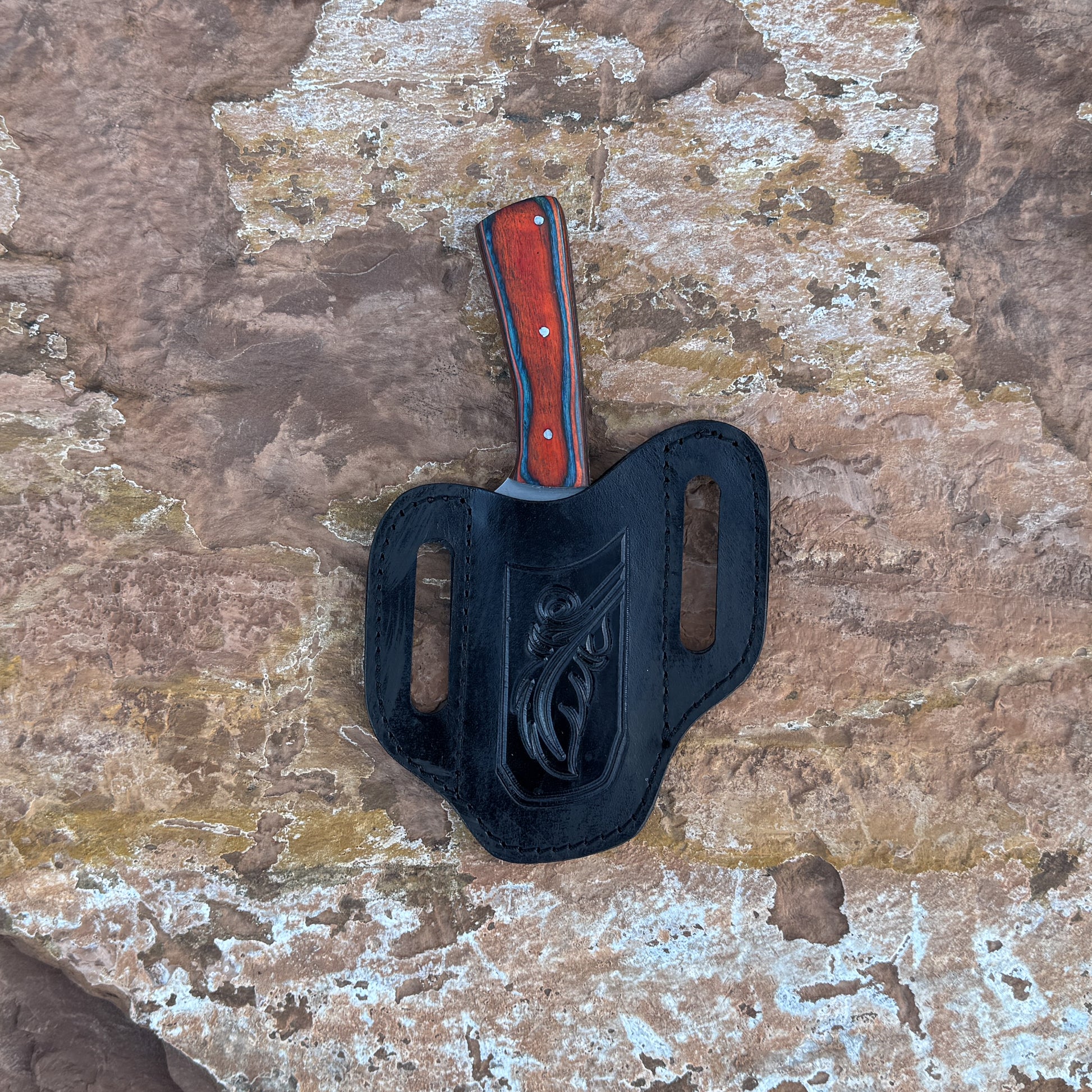 A full-tang drop-point field knife with a satin-finished blade and a richly grained hardwood handle, shown beside a hand-stitched leather sheath. Crafted by Blue Spade Forge for hunting, camping, carving, and rugged outdoor field use.