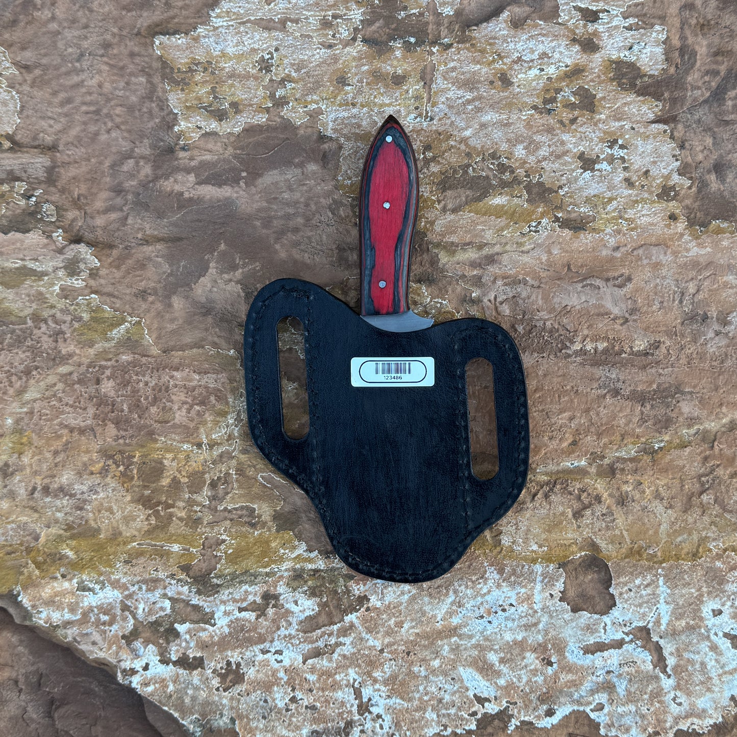 Ember Ridge fixed blade knife with deep red wood handle

Curved high-carbon blade displayed on brown leather sheath

Close-up of red handle with black grain accents and triple pins

Ember Ridge knife on natural wood background

Knife and hand-stitched sheath arranged for product showcase

Rugged outdoor knife in natural lighting

Blue Spade Forge Ember Ridge held in hand for scale

High-carbon field knife ready for hunting and camp tasks