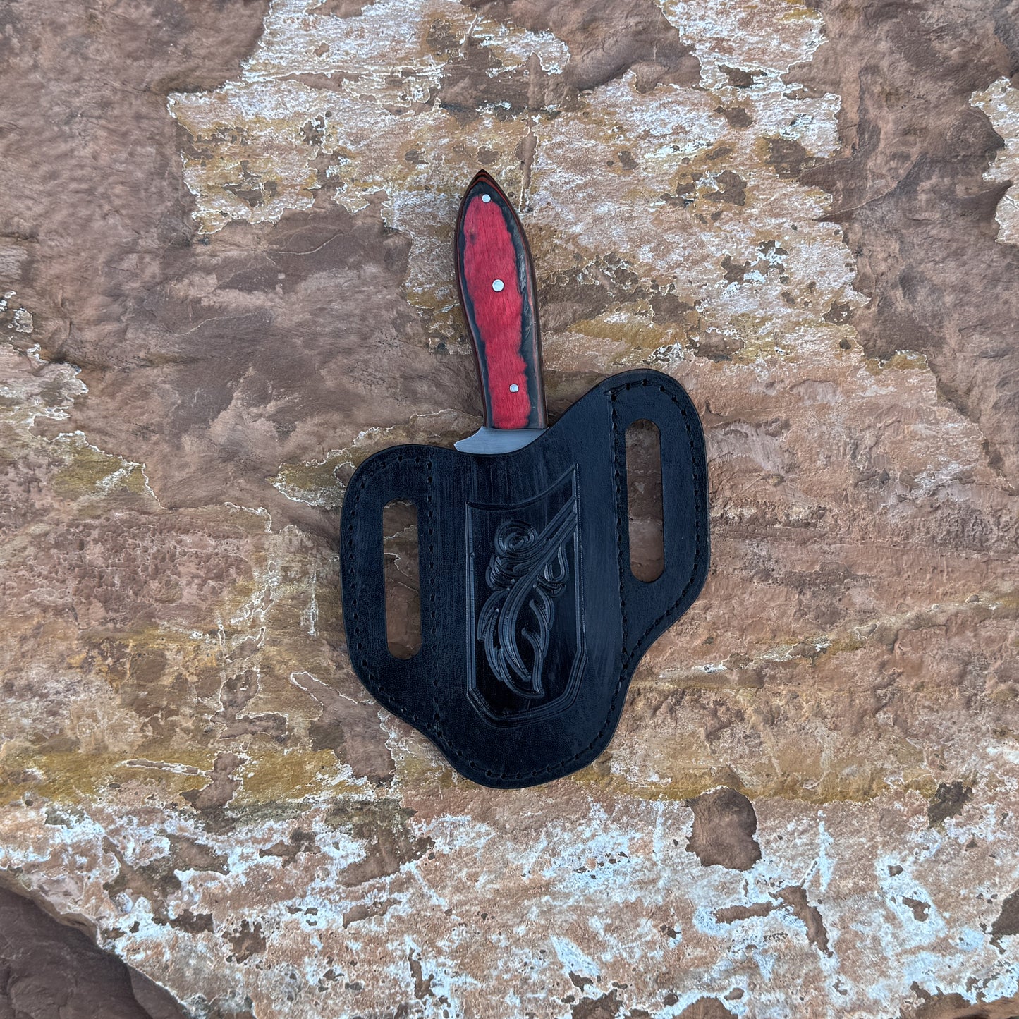 Ember Ridge fixed blade knife with deep red wood handle

Curved high-carbon blade displayed on brown leather sheath

Close-up of red handle with black grain accents and triple pins

Ember Ridge knife on natural wood background

Knife and hand-stitched sheath arranged for product showcase

Rugged outdoor knife in natural lighting

Blue Spade Forge Ember Ridge held in hand for scale

High-carbon field knife ready for hunting and camp tasks