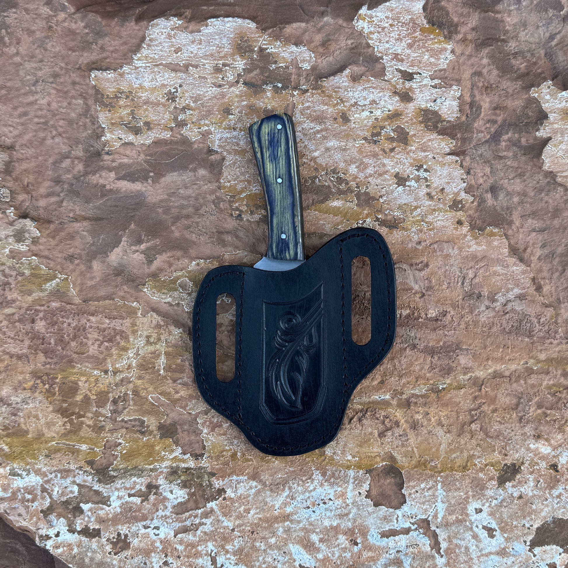 Timber Fang drop-point knife with wood-grain handle

Full-tang outdoor blade displayed on leather sheath

Close-up of dark and light wood grain handle with rivets

Timber Fang knife on natural wood background

Knife and star-accent leather sheath arranged together

Rugged field knife in natural lighting

Blue Spade Forge Timber Fang held in hand for scale

Drop-point fixed blade ready for outdoor field tasks