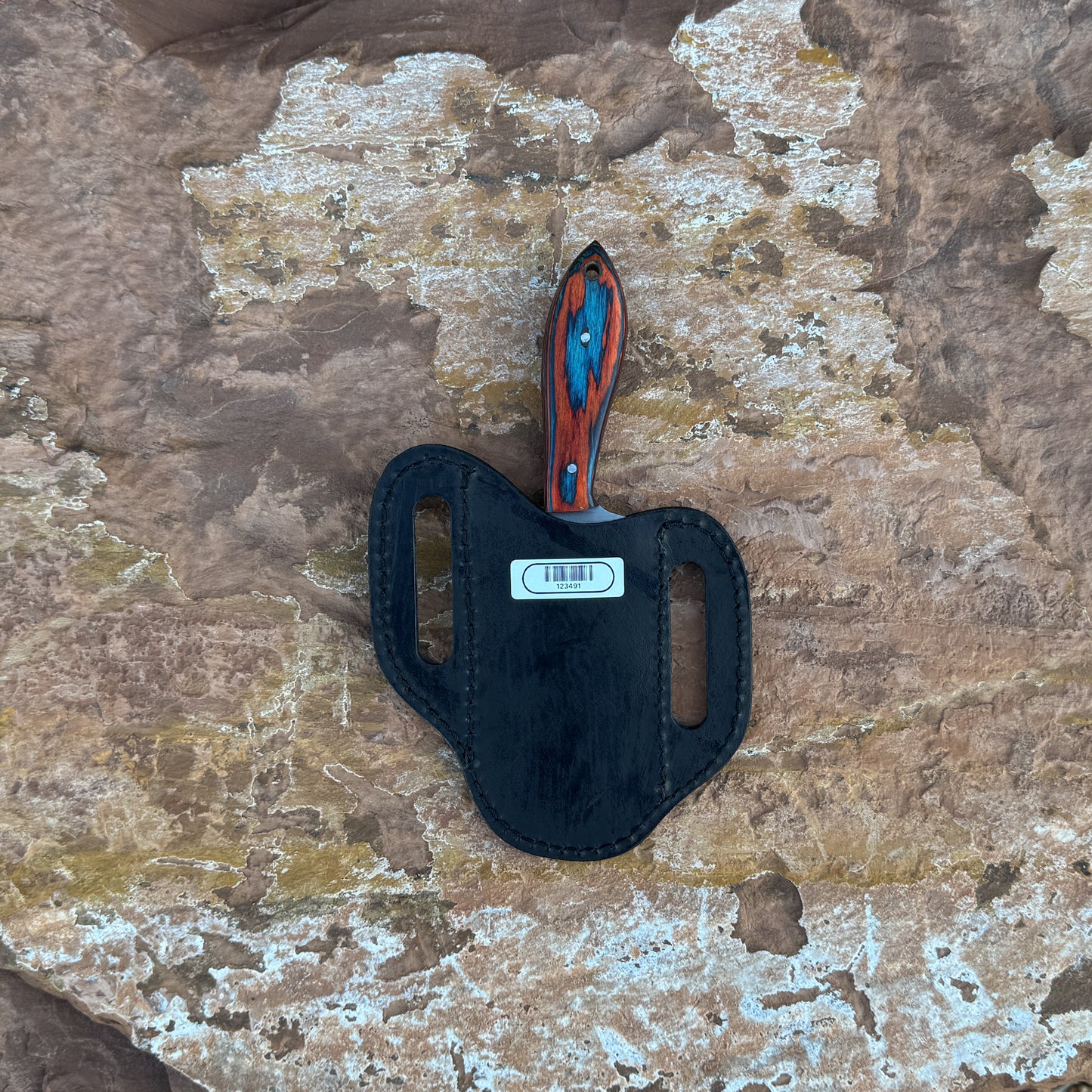 Ridge Cowboy knife with squared cowboy-style blade

Compact cowboy knife displayed on hand-stitched leather sheath

Close-up of multi-tone hardwood handle grain

Ridge Cowboy knife on natural wood background

Knife and leather sheath arranged for product display

Outdoor cowboy-style knife in natural lighting

Blue Spade Forge Ridge Cowboy held in hand for scale

Detail shot of squared blade and multi-tone handle