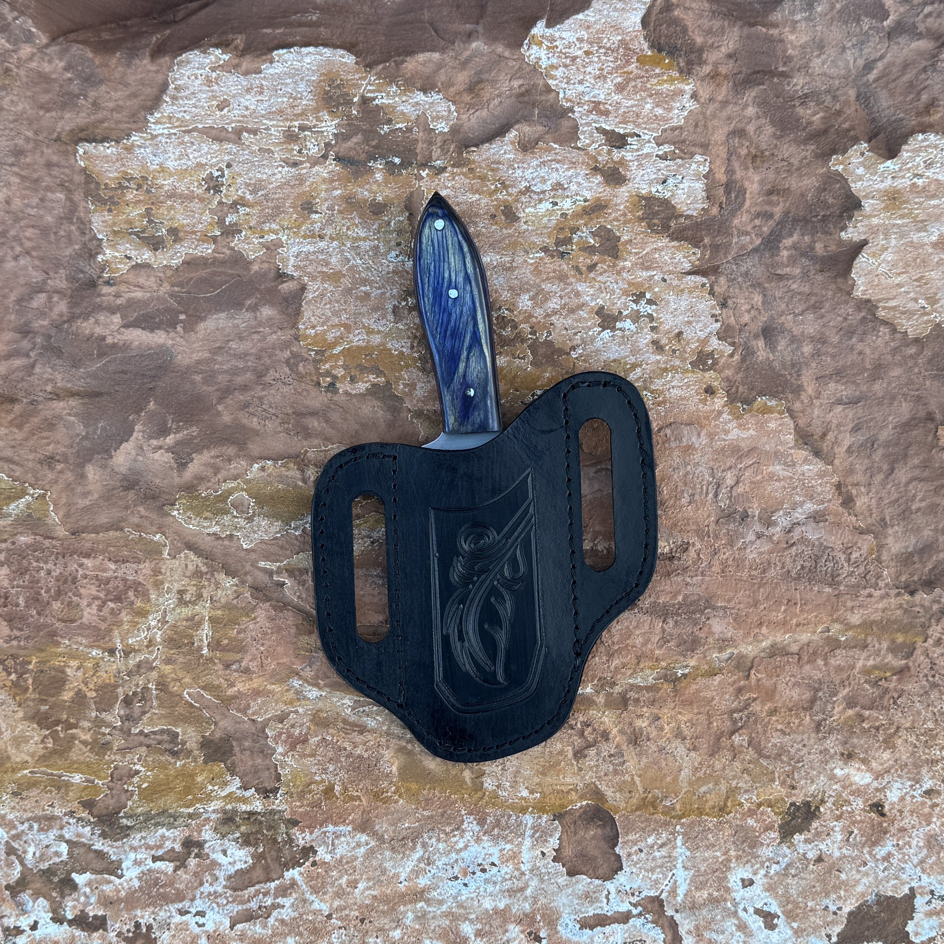 Midnight Ridge stainless fixed blade knife with blue resin handle

Curved stainless blade displayed on hand-stitched leather sheath

Swirled blue resin handle close-up

Midnight Ridge knife on natural wood background

Knife and leather sheath arranged for product display

Outdoor field knife in natural lighting

Blue Spade Forge Midnight Ridge held in hand for scale

Stainless fixed blade ready for trail and outdoor use