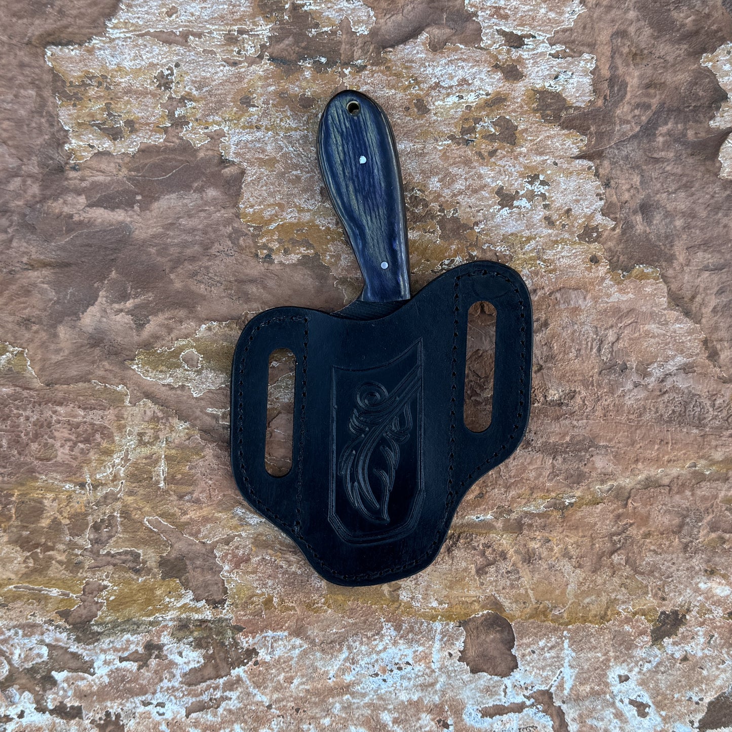 Shadow Rasp Hunter knife with rasp-textured blade

Curved high-carbon steel blade on leather sheath

Dark hardwood handle with rivets close-up

Shadow Rasp Hunter displayed on natural wood background

Knife and hand-stitched sheath arranged for product showcase

Outdoor fixed blade knife in natural lighting

Blue Spade Forge Shadow Rasp Hunter held in hand for scale

Rasp-spine blade and hardwood handle detail shot