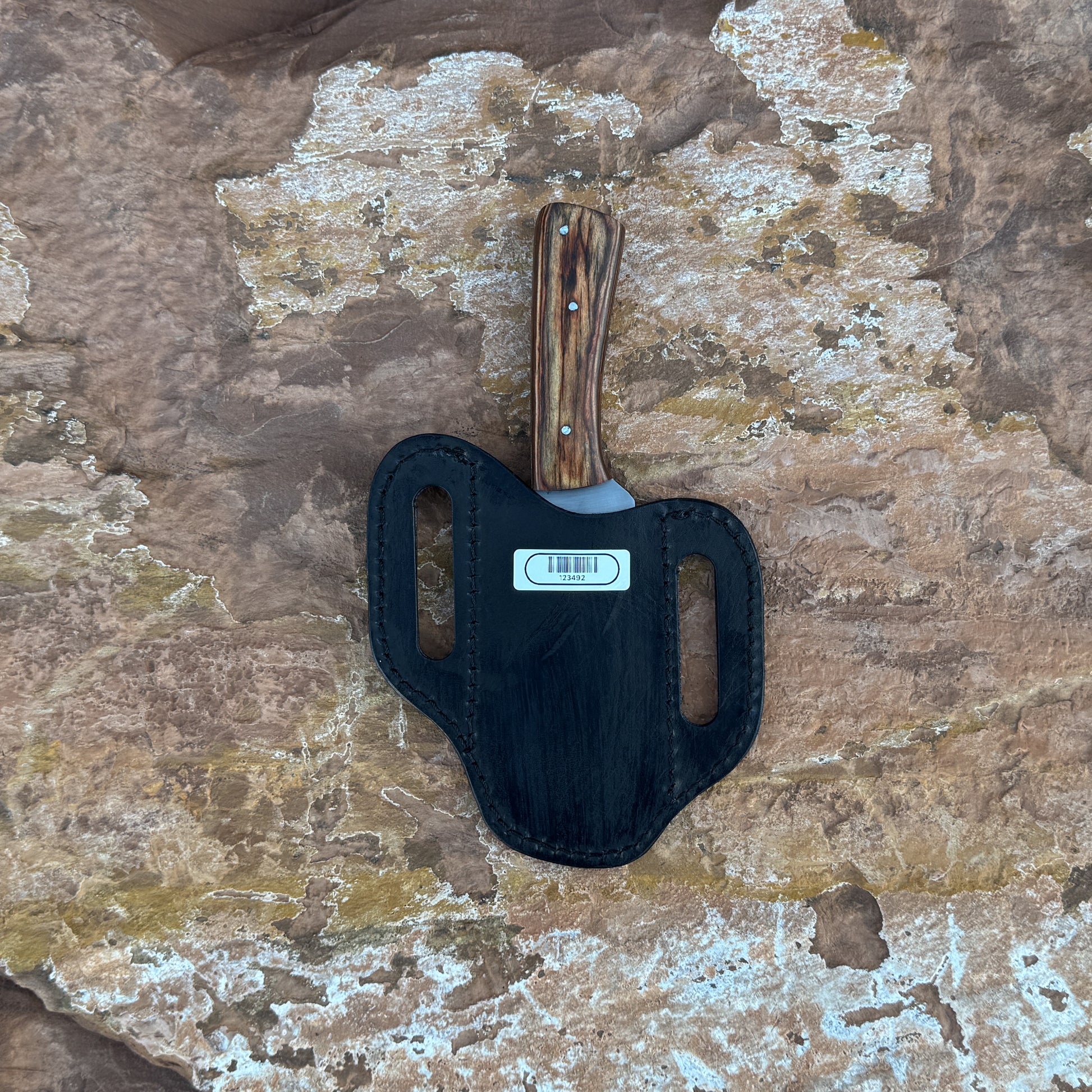 A straight-back fixed blade knife with a stainless-steel blade and contoured natural-wood handle, shown with its hand-stitched brown leather sheath. Designed by Blue Spade Forge for bushcraft, hunting, and versatile outdoor field use.