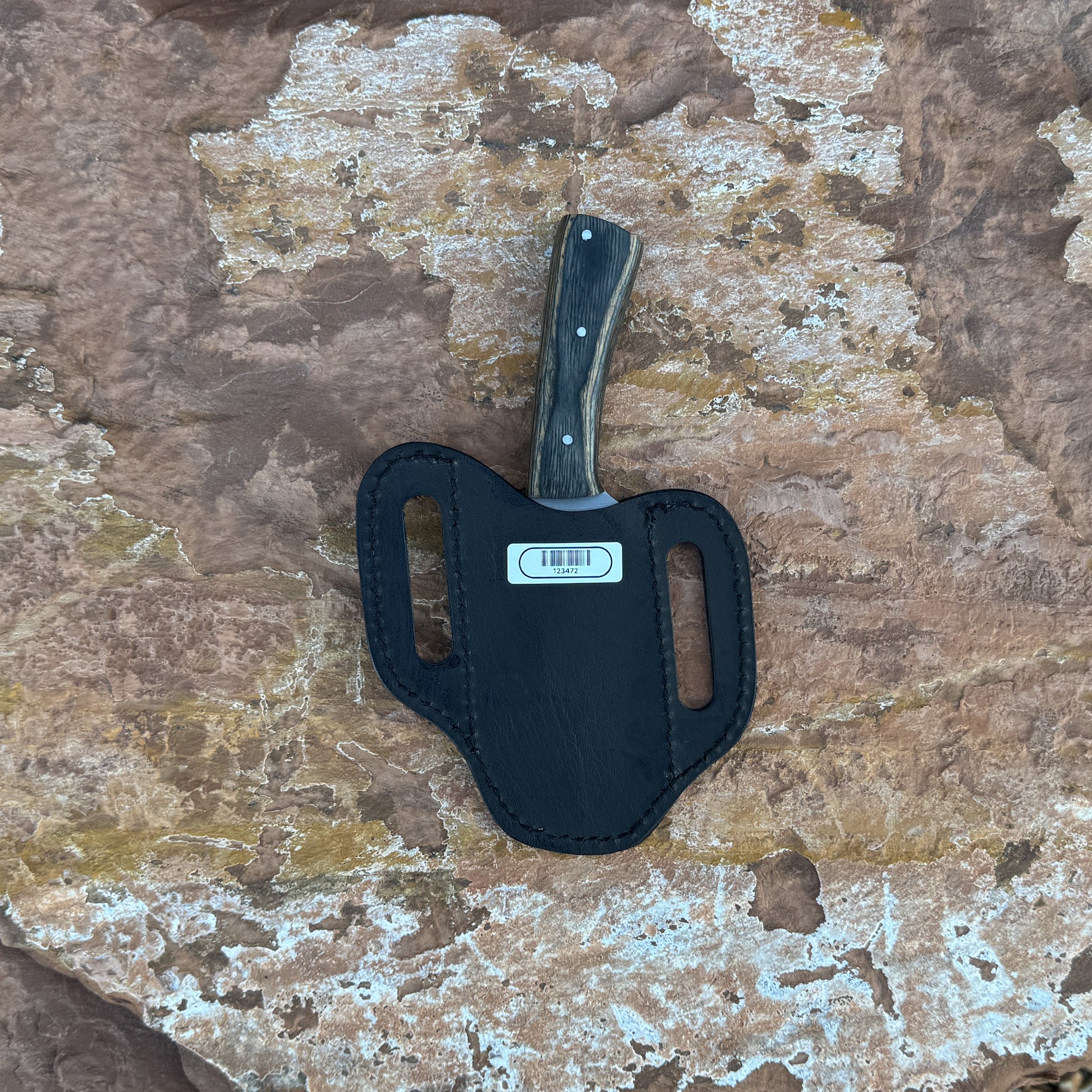A full-tang drop-point field knife with a satin-finished blade and dark-wood handle, triple-riveted for strength, photographed for Blue Spade Forge. Shown with its handcrafted leather sheath, highlighting the rugged outdoor style and premium construction
