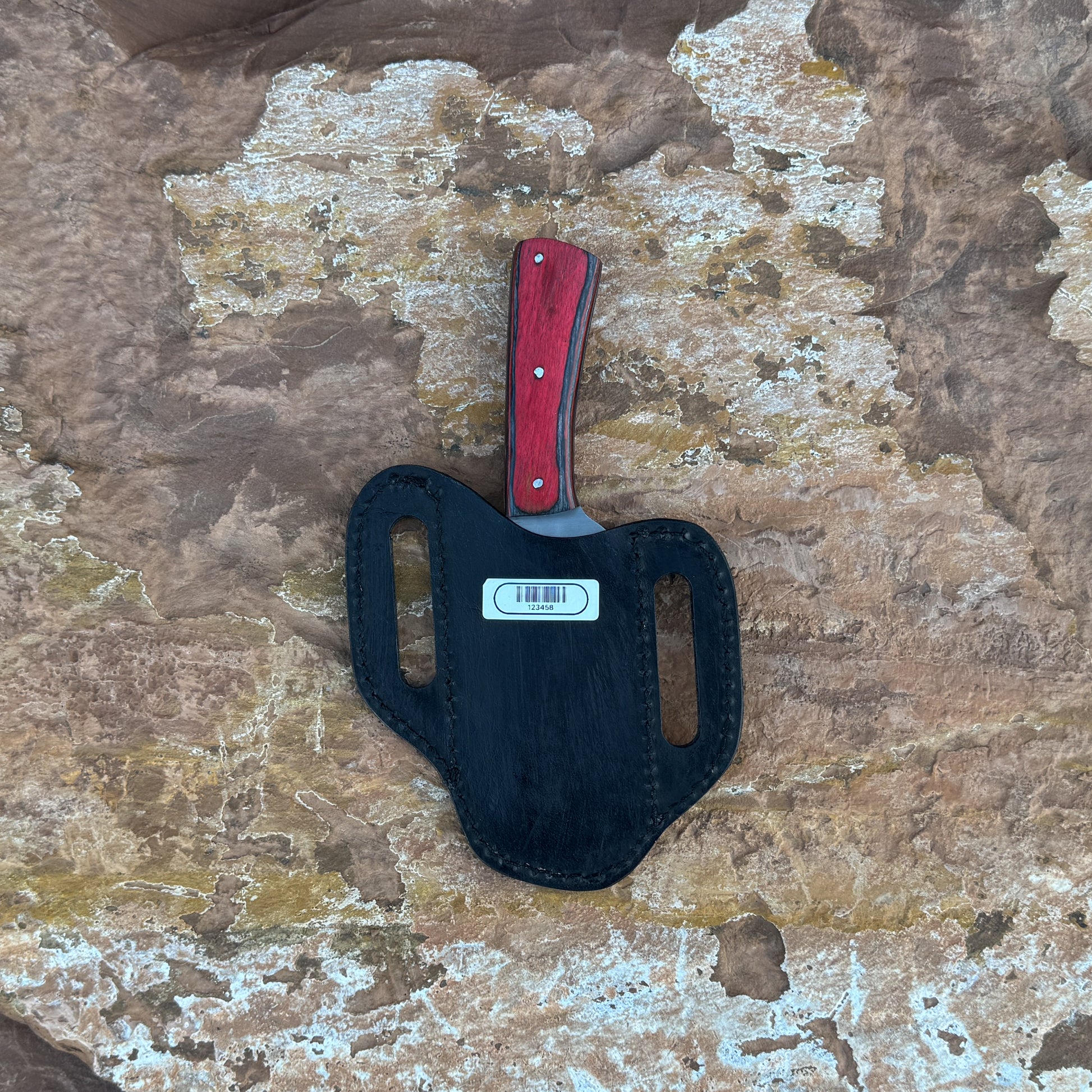 Crimson Forge Field Knife with red-grained hardwood handle

Drop-point satin blade displayed on leather sheath

Close-up of red hardwood handle with dual rivets

Field knife on natural wood background

Crimson Forge knife and hand-stitched sheath arranged together

Outdoor fixed blade in natural lighting

Blue Spade Forge Crimson Forge held in hand for scale

Drop-point blade and hardwood handle detail shot
