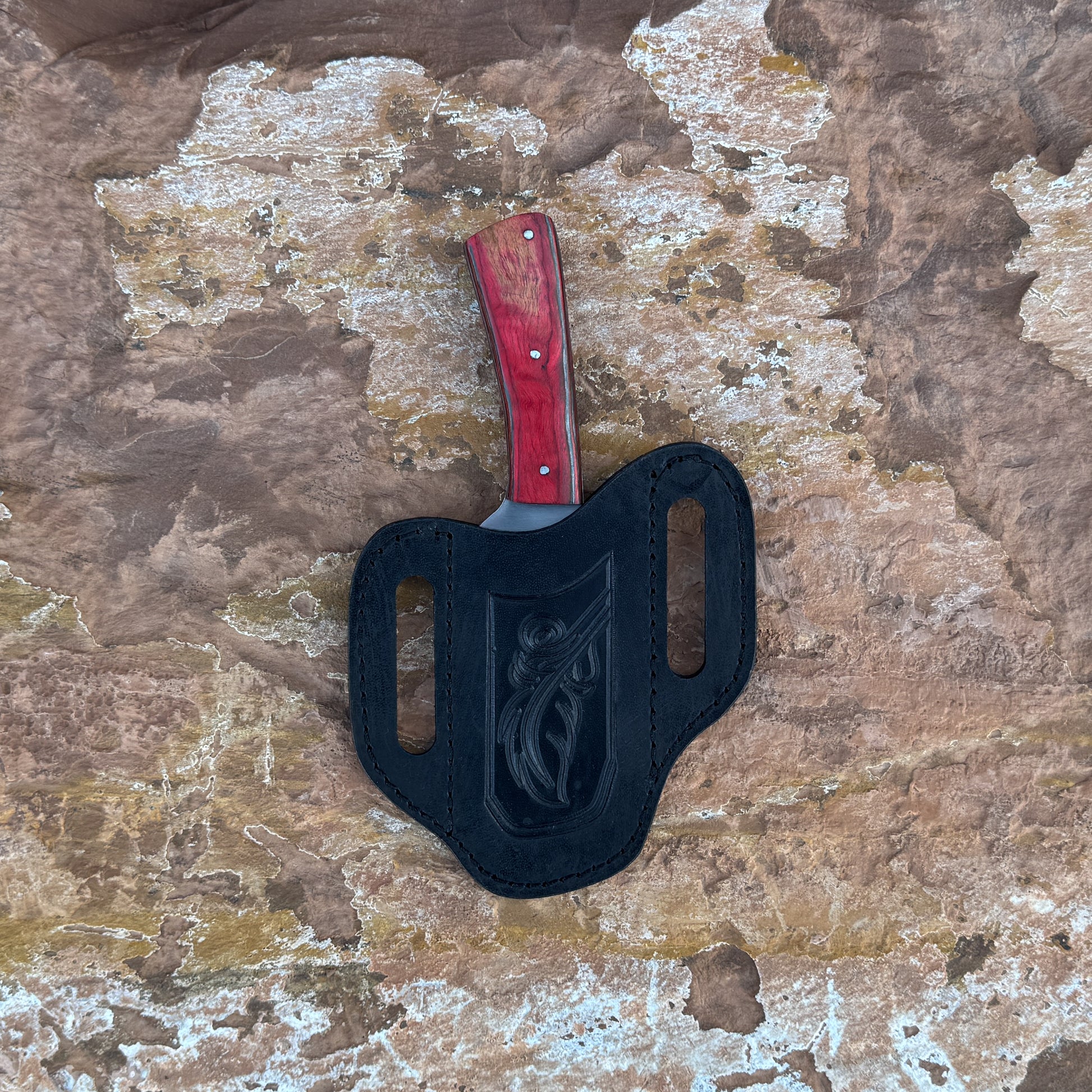 Crimson Forge Field Knife with red-grained hardwood handle

Drop-point satin blade displayed on leather sheath

Close-up of red hardwood handle with dual rivets

Field knife on natural wood background

Crimson Forge knife and hand-stitched sheath arranged together

Outdoor fixed blade in natural lighting

Blue Spade Forge Crimson Forge held in hand for scale

Drop-point blade and hardwood handle detail shot