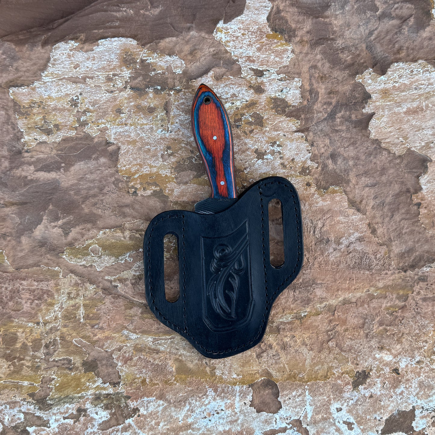 Red Ember Rasp Cleaver with red and blue hardwood handle

Close-up of rasp-textured spine on cleaver blade

Cleaver-style knife displayed on hand-stitched leather sheath

Full-tang cowboy cleaver on rustic wood background

Handle detail showing red-blue grain and brass hardware

Blade profile highlighting chopping edge and spine texture

Blue Spade Forge Red Ember Cleaver held in hand for scale

Leather sheath detail with stitching and natural finish