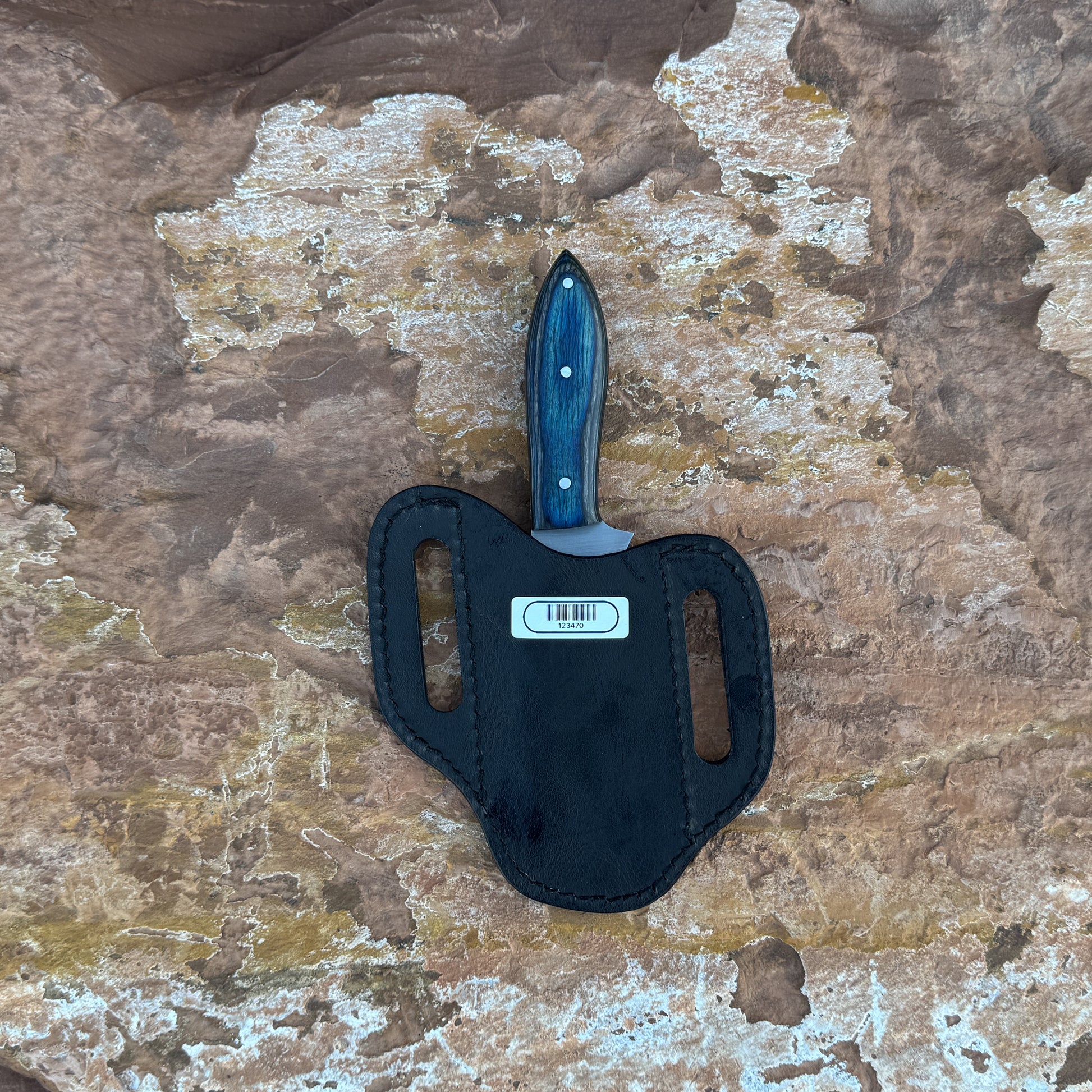 A full-tang upswept hunting knife with a satin-finished blade and deep-blue hardwood handle, reinforced with triple rivets. Shown alongside its hand-stitched leather sheath, crafted by Blue Spade Forge for field work, hunting, and rugged outdoor use.